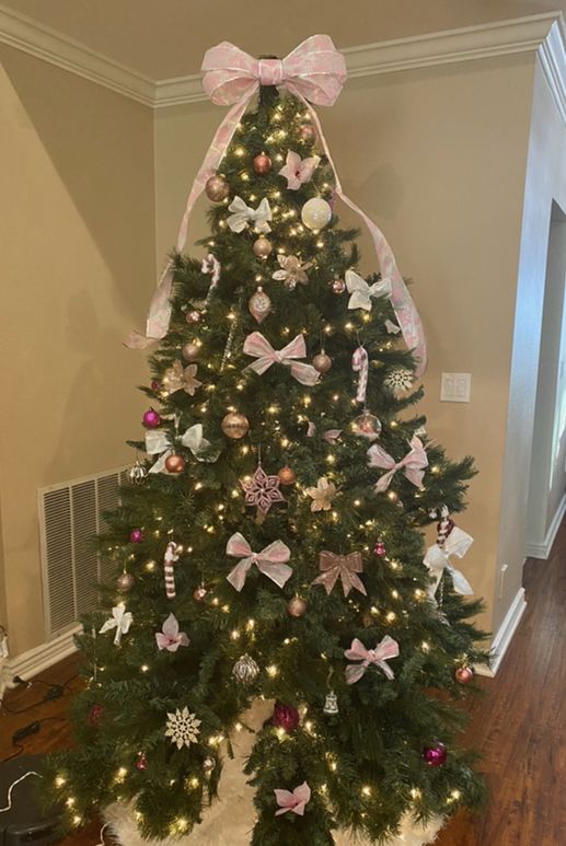 a decorated christmas tree with pink and white bows