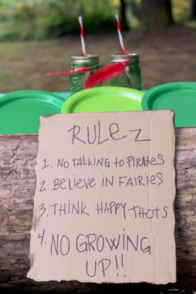 a sign on a log that says rules 2 no talking to pirates believe in fairies 3 think happy hots 4 no growing up