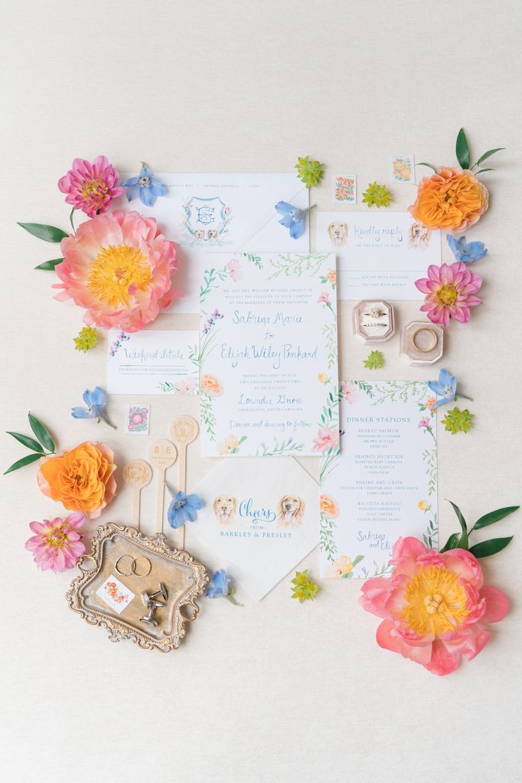 the wedding stationery is laid out with flowers and other things to put on it