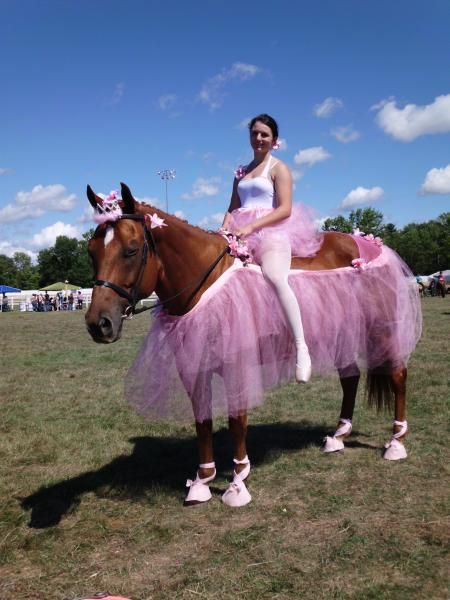 a woman in a pink tutu riding a horse