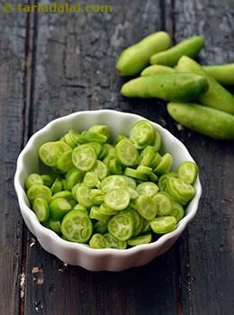 a white bowl filled with green beans on top of a wooden table