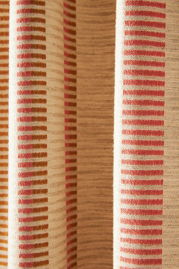 an orange and beige striped curtain with vertical stripes on it's side, closeup