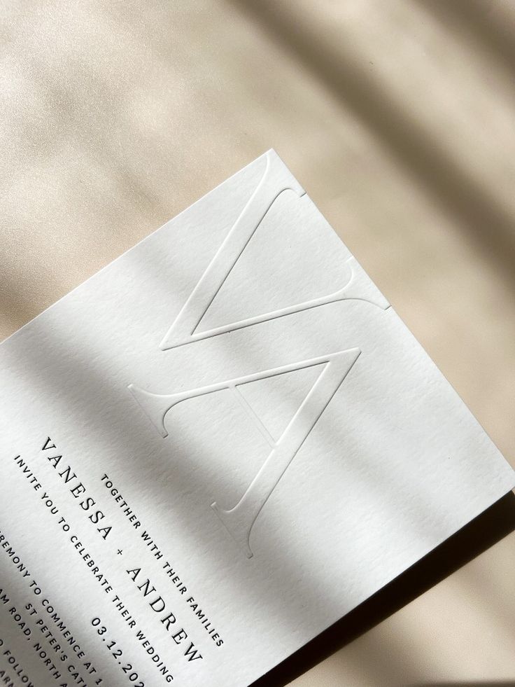 a close up of an opened book on a white table cloth with the letter w