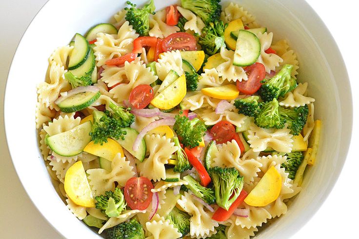 a white bowl filled with pasta and veggies