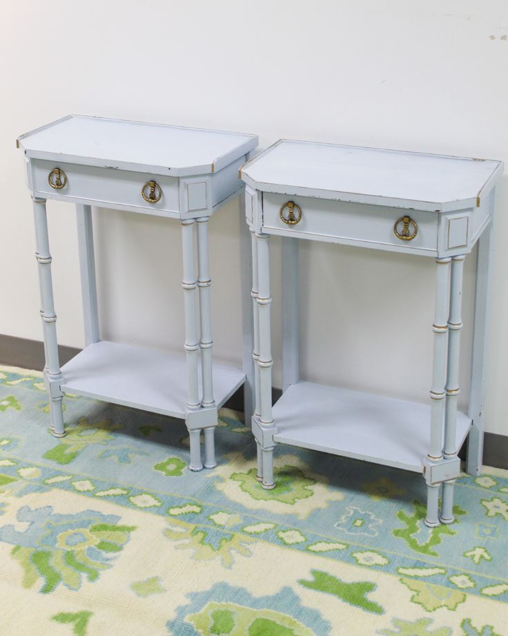 two blue nightstands sitting next to each other on a rug