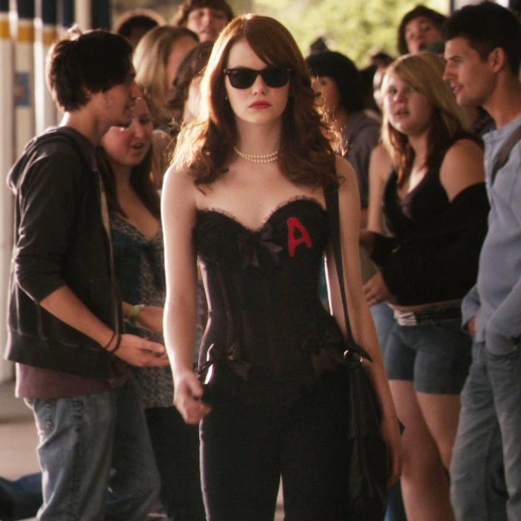 a woman in a corset and sunglasses standing next to a group of people