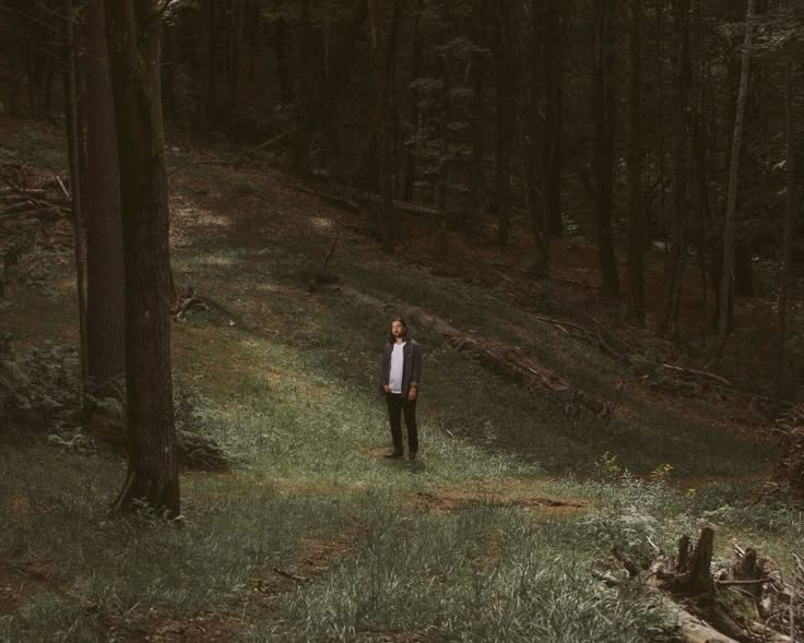 a man standing in the middle of a forest