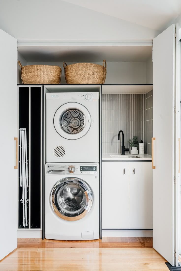 a washer and dryer sitting in a room next to each other on top of a wooden floor