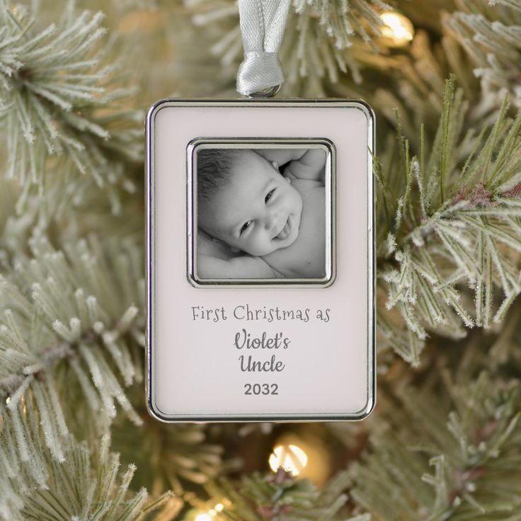 a baby's first christmas ornament hanging from a tree