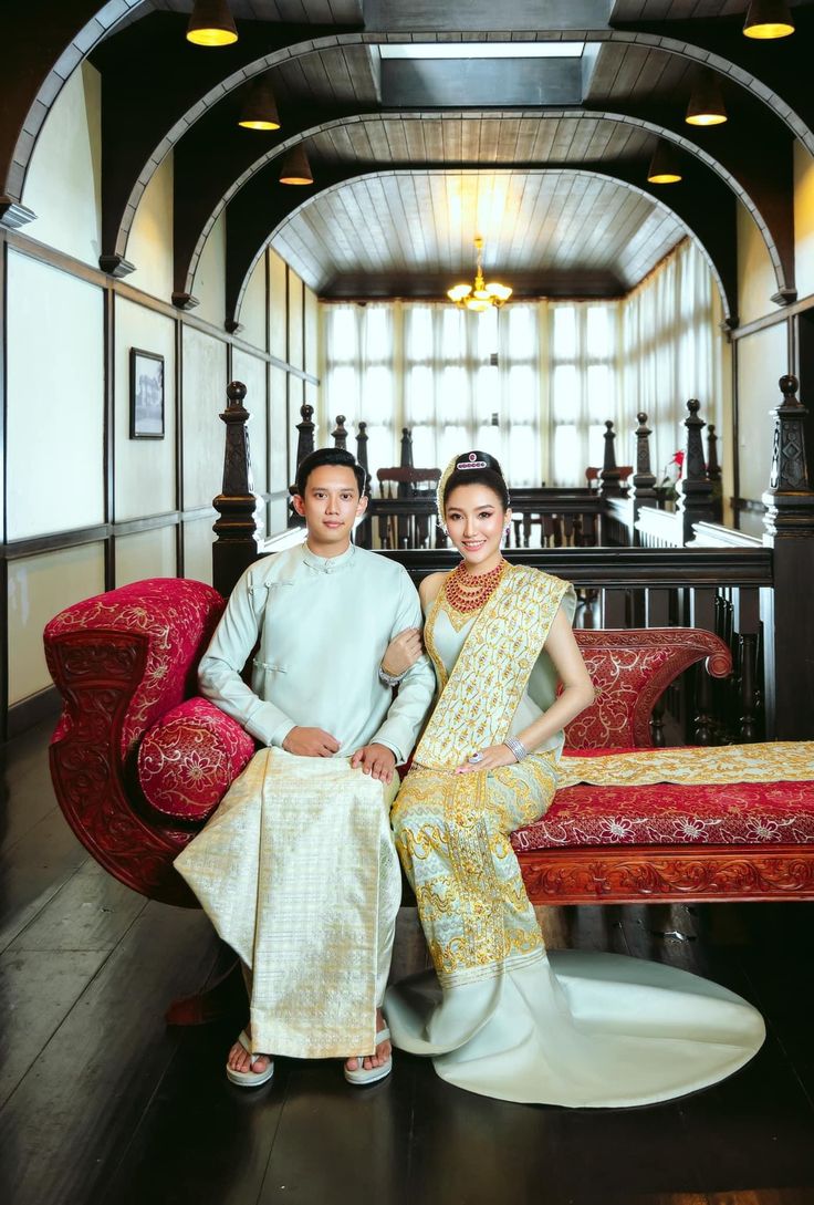 a man and woman sitting on a bench in front of a room filled with furniture