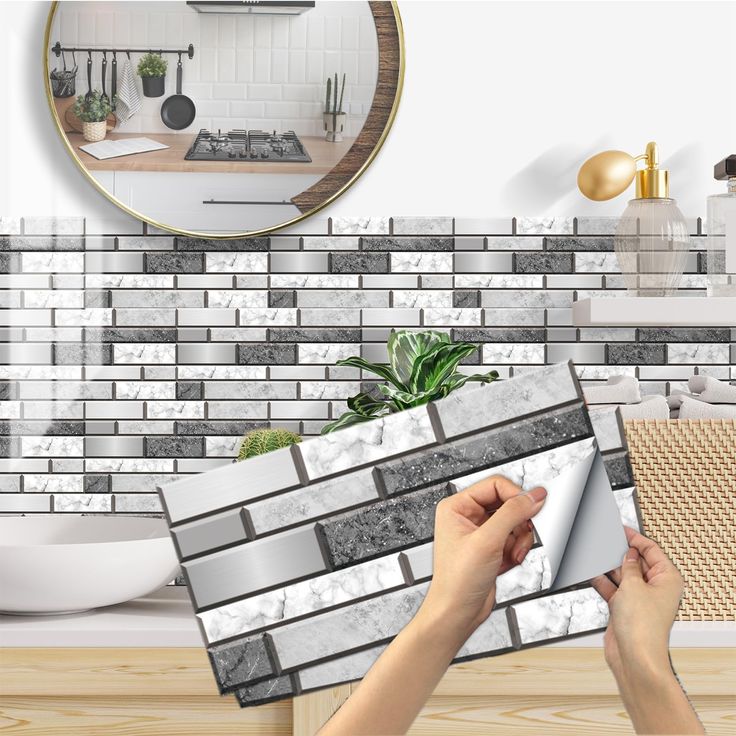 a person is placing tile on the wall