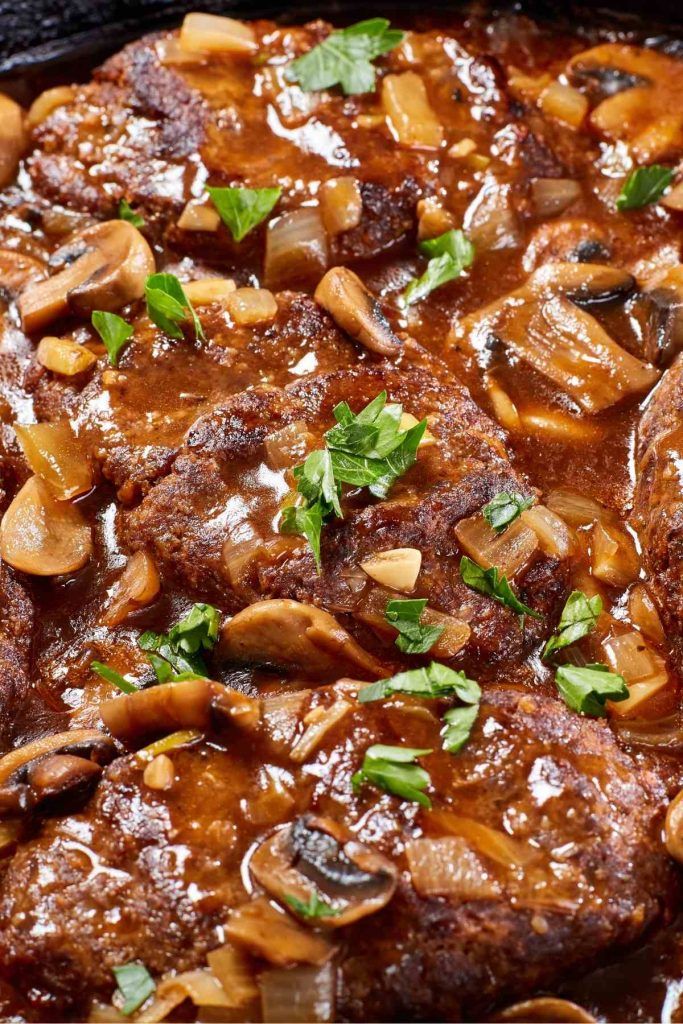 meat with mushrooms and sauce in a skillet ready to be served for dinner or as an appetizer