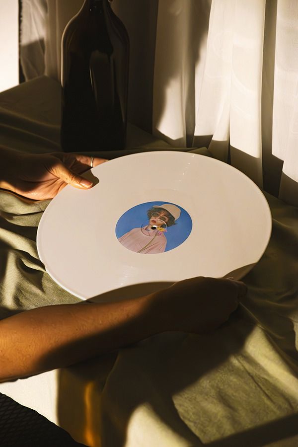 a person holding a plate with a photo on it and a bottle in the background