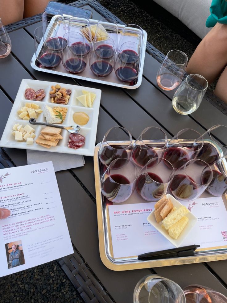 several glasses of wine, cheese and crackers on a table