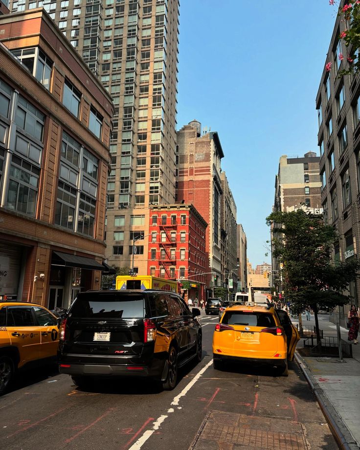 cars are parked on the side of the road in front of tall buildings and skyscrapers