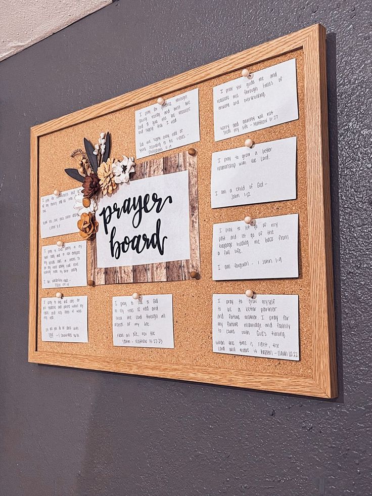 a bulletin board with notes attached to the side of it that says prayer board and flowers