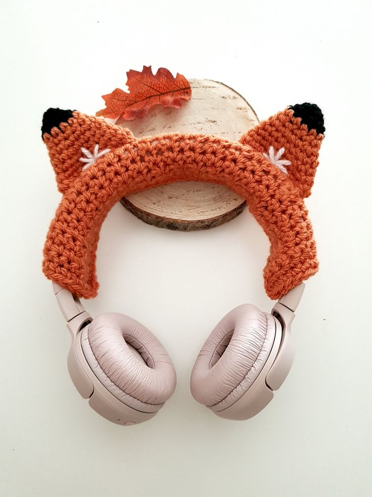 a pair of headphones with an orange knitted fox ear cover on top of it