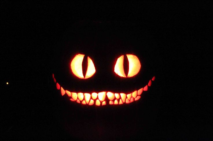 an illuminated pumpkin with glowing eyes in the dark