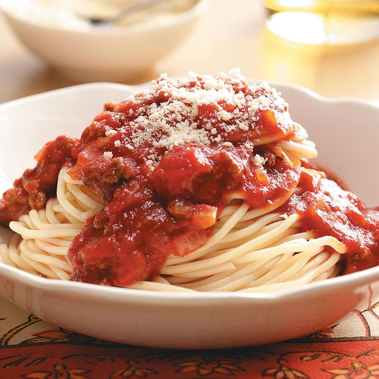 a white bowl filled with spaghetti and sauce