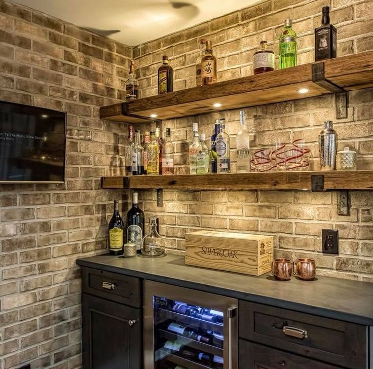 a brick wall with shelves filled with liquor bottles and wine glasses on top of it