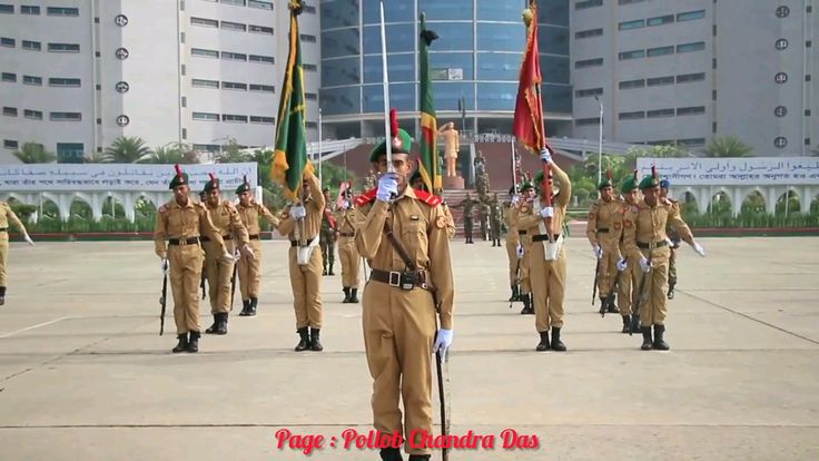 men in uniform are marching through the street with flags on their heads and holding poles