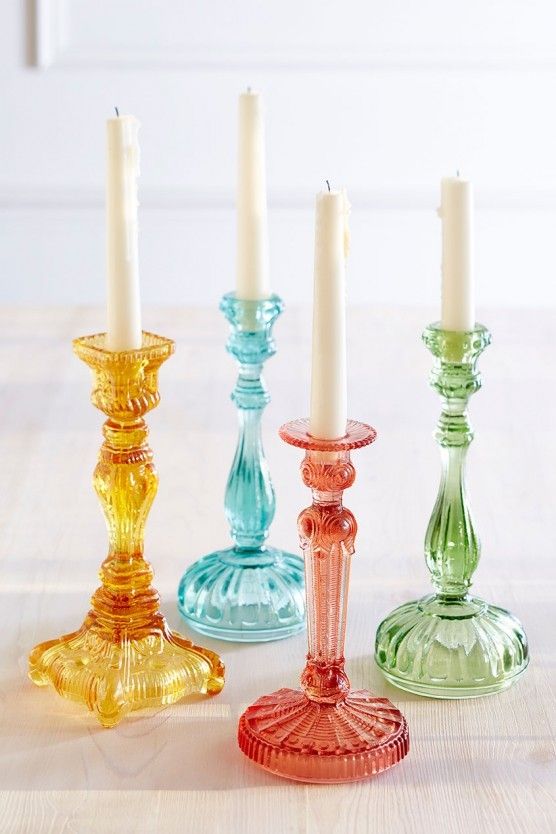 three glass candlesticks sitting next to each other on a table