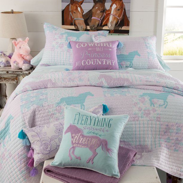 a bed with two horses on the cover and pillows