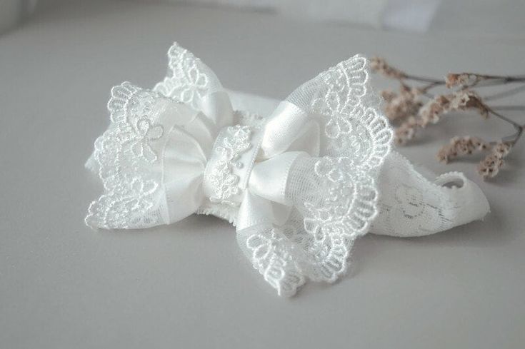 FAIRY DUST HANDMADE Beautiful scalloped lace bow on a stretchy soft lace headband. Unique Fairy Dust Headbands design! Handmade in the UK Especially designed for baby girls, newborns, flower girls Making Process: Headband is made from comfortable to wear lace elastic. Bow is made from a beautiful lace with scalloped edge and satin ribbon. Bow is finished with felt at the back for comfortable wear. Headband looks very elegant on both little and older girls. Occasion: Perfect for christening, baptism, wedding and any other formal occasion. Measurements: Approximate elastic sizes: Newborn  13'' 3-6m         15'' 6m-2yrs    16'' 2yrs onwards  17'' Bow measures approximately  4 inches. WARNING: Children must be supervised by parents while wearing this hair band due to small parts! Comes from a Adjustable White Bow For Wedding, White Adjustable Bow For Wedding, Cute Ribbon Bow For Wedding, White Lace Headband For Party, White Lace Party Headband, Elegant Lace Hair Accessories For Wedding, Adjustable White Headband For First Communion, Elegant Baptism Hair Accessories With Matching Headband, White Bow Headband For Wedding