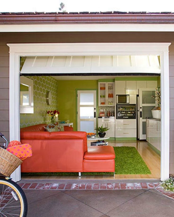 a bicycle parked in front of a garage with an orange couch on the door way