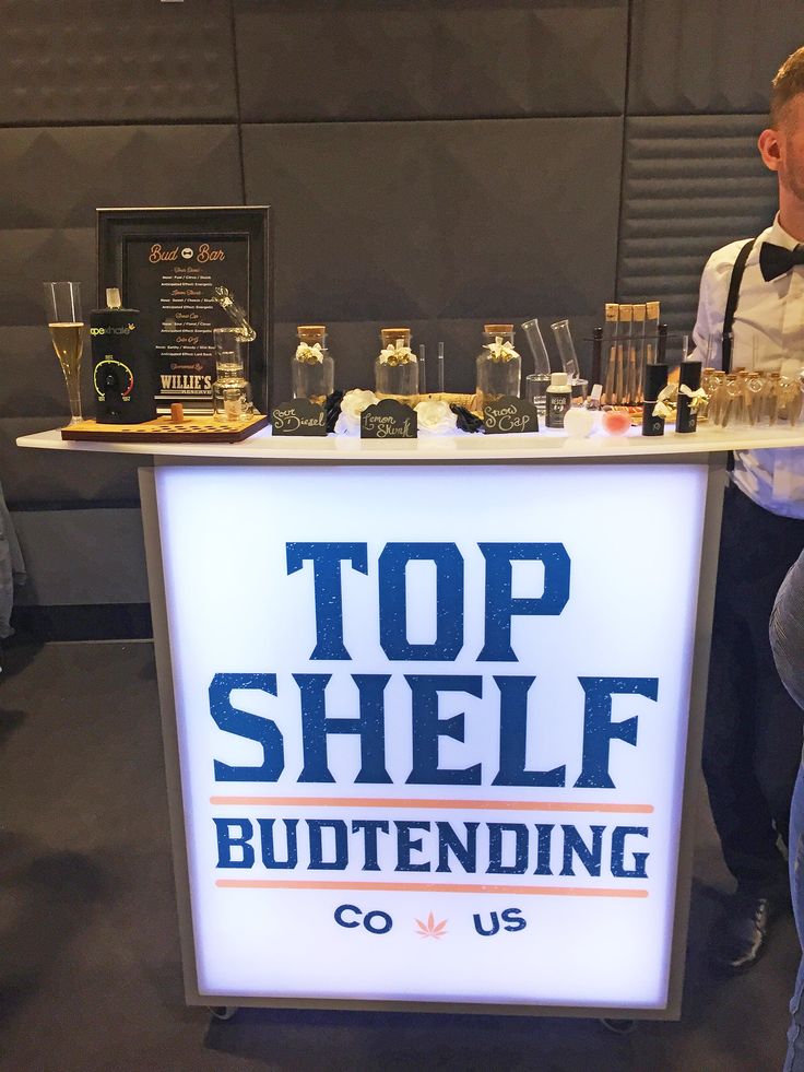 a man standing next to a counter with bottles on it