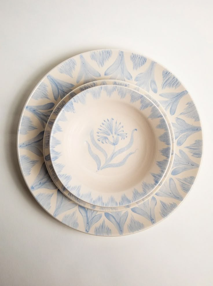 two blue and white plates sitting on top of each other