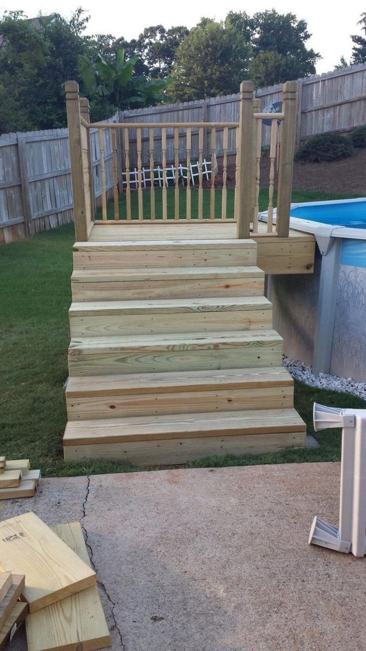 an above ground pool with steps leading up to it and a wooden fence around it