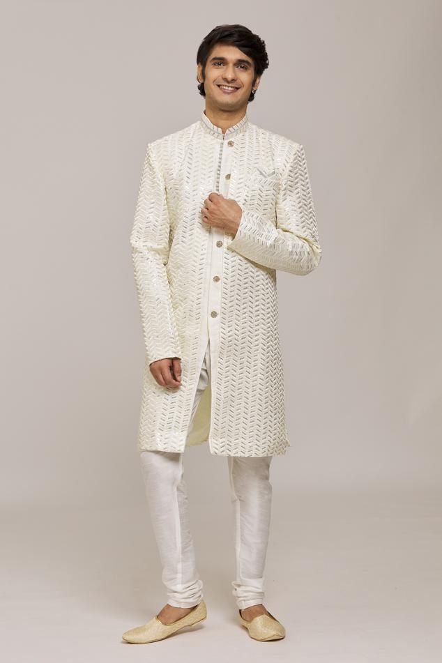 Off white sherwani with overlay sequin embroidered chevron patterns. Comes with churidar.
Components: 2
Pattern: Embroidered
Type Of Work: Sequin
Neckline: Mandarin Collar
Sleeve Type: Full
Fabric: Sherwani: Computer Embroidery Jacquard, Churidar: Silk Dupion
Color: Off White
Other Details: 
Embellished buttons
Closure:
Sherwani: Front button
Churidar: Drawstring
Note: Pocket square worn by the model is not for sale
Occasion: Sangeet,Mehendi and Puja - Aza Fashions Semi-stitched White Nehru Jacket For Wedding, Off White Traditional Wear With Zari Work For Reception, White Bollywood Traditional Wear For Reception, White Semi-stitched Nehru Jacket For Festivals, White Traditional Wear With Resham Embroidery For Reception, White Traditional Wear With Chikankari Embroidery For Reception, White Semi-stitched Bandhgala With Zari Work, Fitted White Bollywood Nehru Jacket, White Fitted Bollywood Nehru Jacket