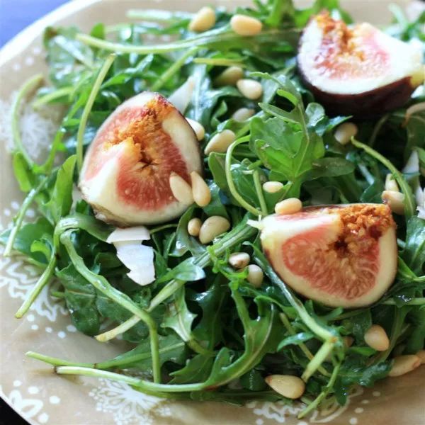 a white plate topped with greens and figs