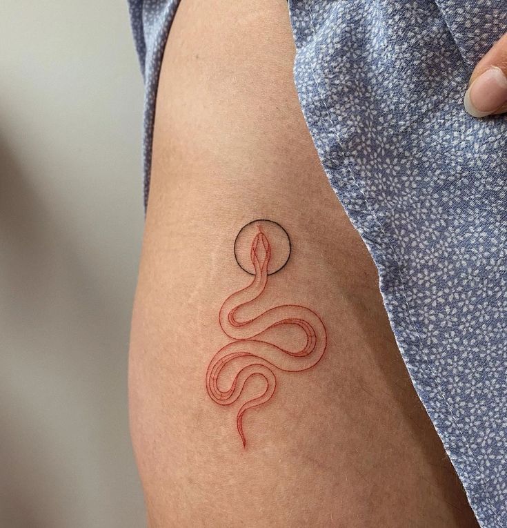 a person with a tattoo on their arm that has a snake in the middle of it