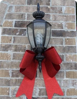 a red ribbon attached to a light on a brick wall