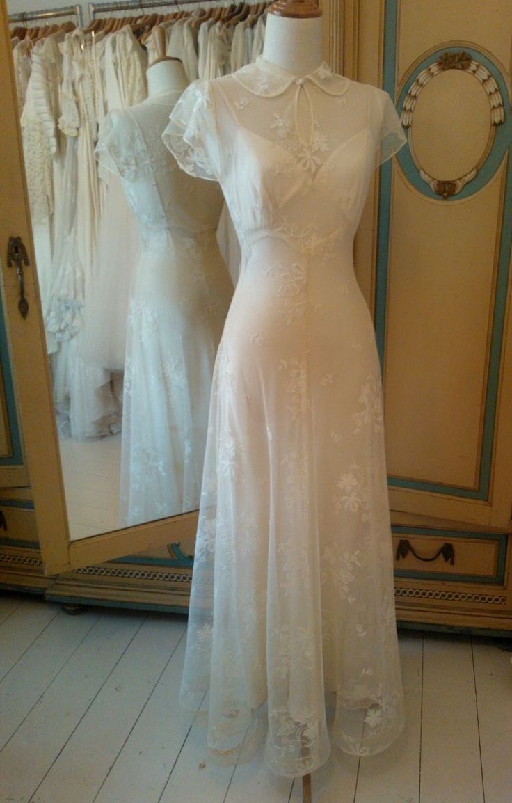 a white dress is on display in front of a mirror and mannequins