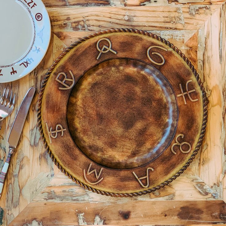 a wooden table topped with a plate and silverware