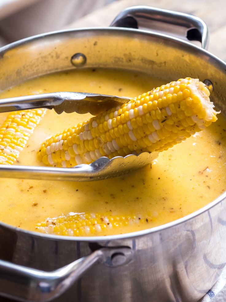 a metal pot filled with corn on the cob