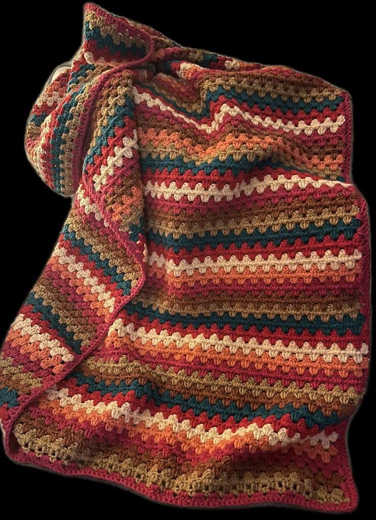 a crocheted blanket that is laying on the ground