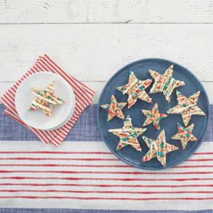 some cookies are on a plate next to a striped table cloth