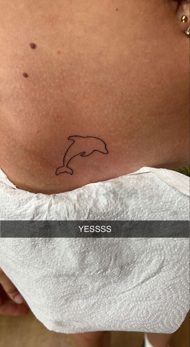 a woman's stomach with a dolphin tattoo on her belly and the words, nessess