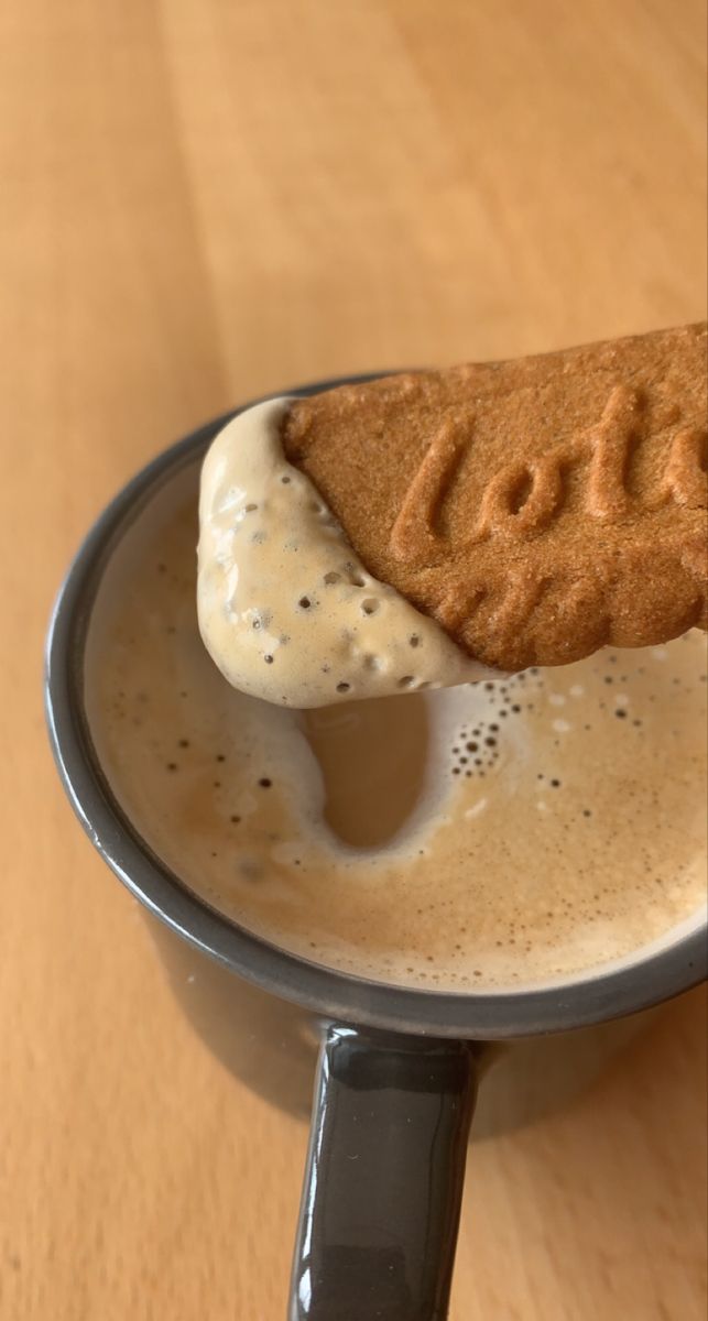 an ice cream scooping out of a cup on top of a wooden table,