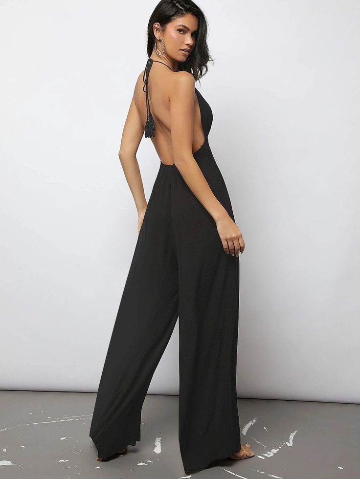 Introducing our Plunging Neck Tied Backless Wide Leg Jumpsuit - a chic addition to your wardrobe. The plain pattern is elevated by a backless and tie back design, adding a touch of glamour to this cami-type jumpsuit. The long length and wide leg fit make this perfect for any occasion, while the halter neckline and sleeveless design offer a flattering and comfortable fit. The high waistline accentuates your curves, creating a stunning silhouette. This jumpsuit is a must-have in your collection. S Comfy Jumpsuits, Plunging Neck, Back Design, Halter Neckline, Wide Leg Jumpsuit, Black Pattern, Plunging Neckline, Long Length, Tie Back