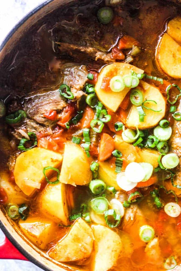 a pot filled with stew and vegetables on top of a table