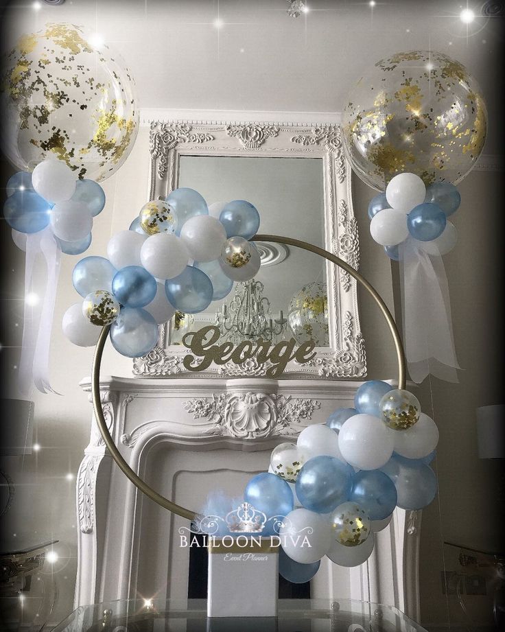 some balloons are hanging from the ceiling in front of a fire place and mirror with lights on it