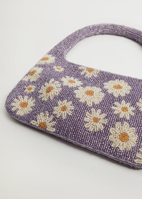 a purple purse with white daisies on it