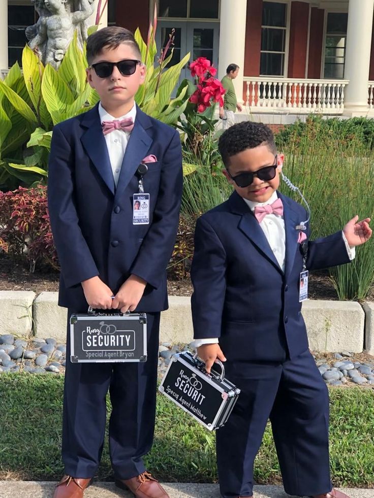 two young boys dressed up in suits and holding signs