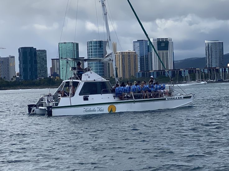 a group of people riding on the back of a white boat in the middle of water