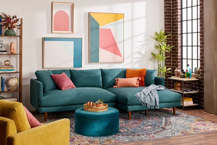 a living room filled with lots of furniture and paintings on the wall above it's windows